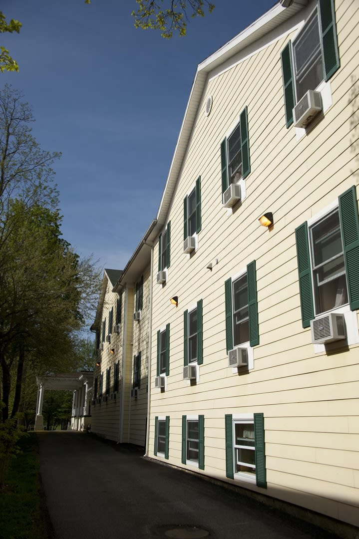 A residential building with multiple windows and air conditioning units under a clear blue sky.