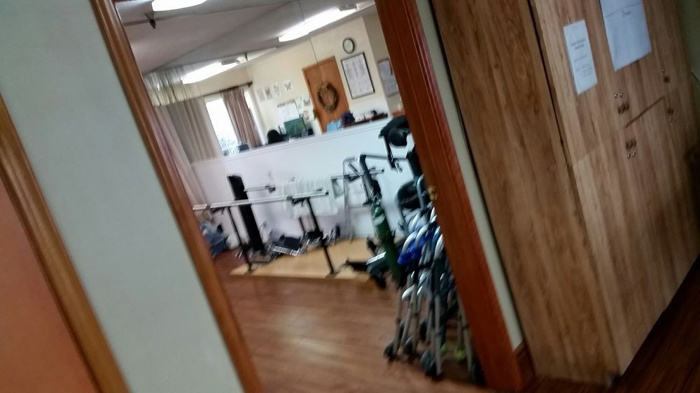View of an office or lobby area with wheelchairs and furniture through a doorway.