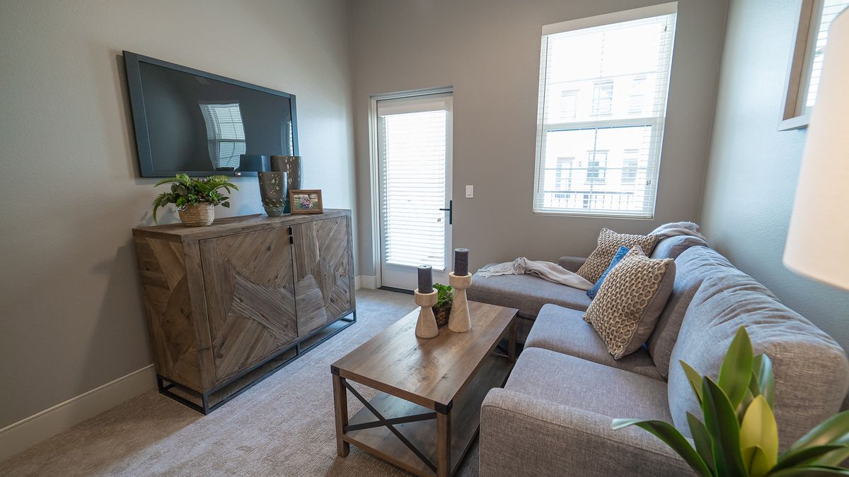 A modern living room with a comfortable sofa, wooden coffee table, and wall-mounted television.