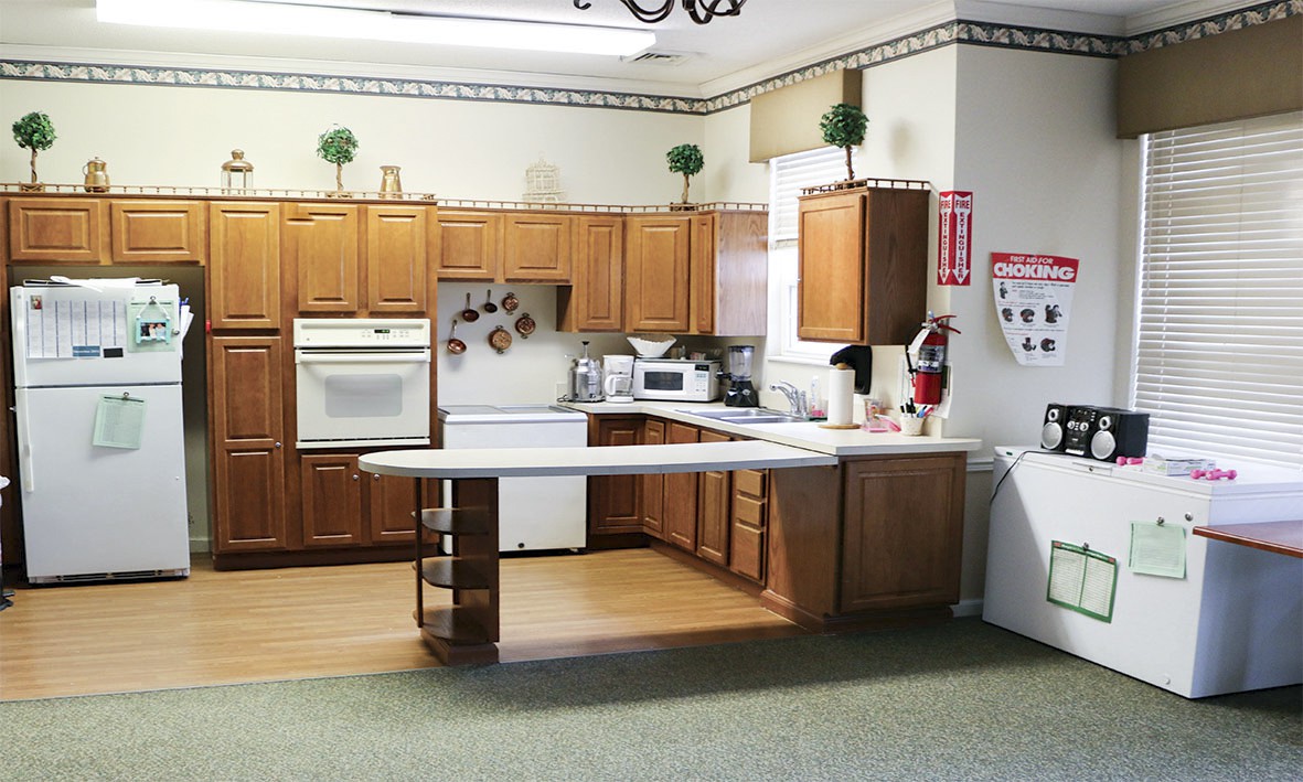 A spacious kitchen featuring wooden cabinets, a countertop, and various appliances.
