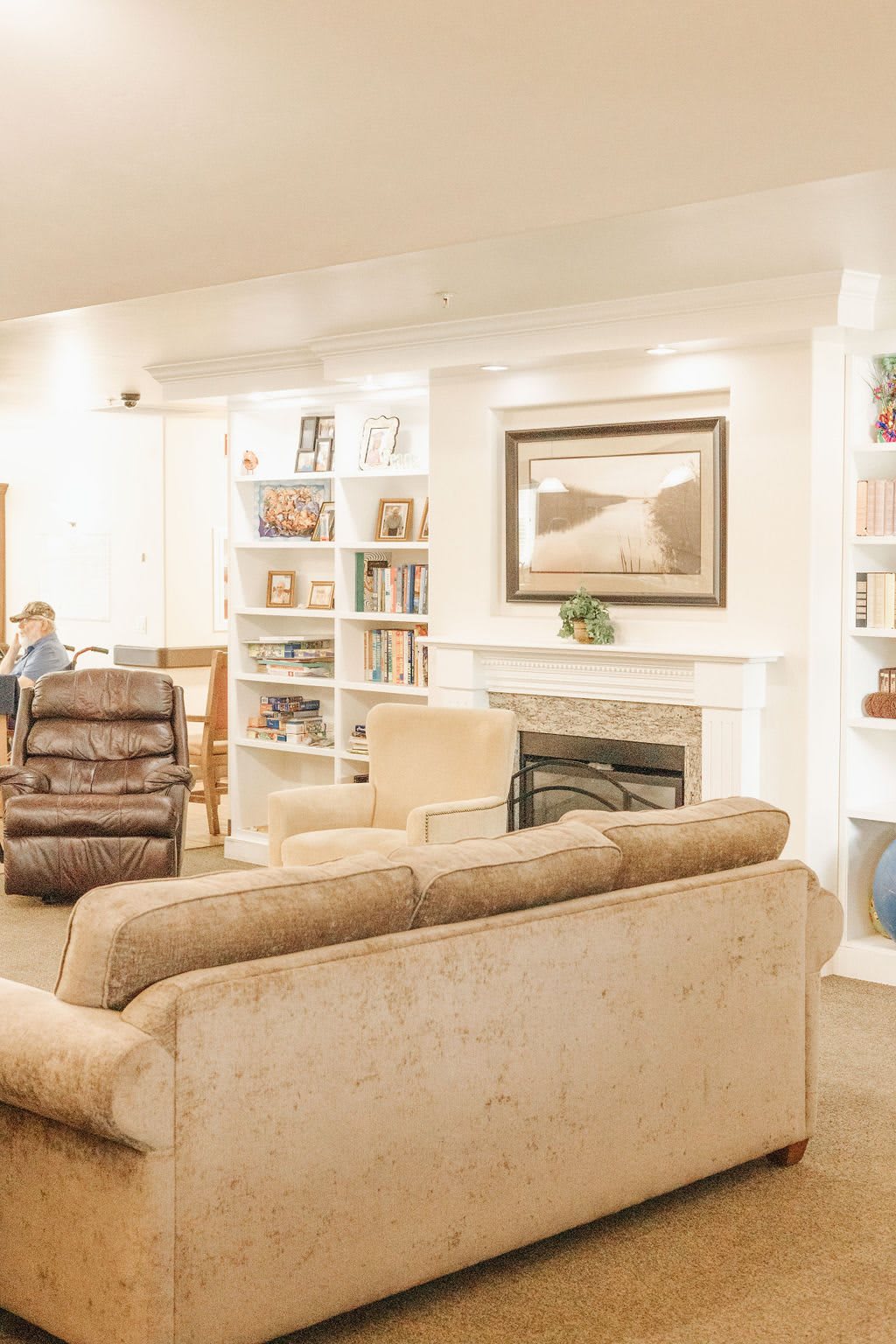 A cozy living room with comfortable seating, bookshelves, and a fireplace.