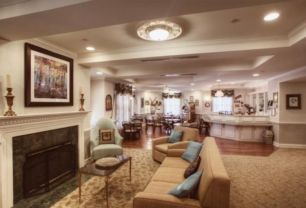 A cozy living room interior with a fireplace, comfortable seating, and elegant lighting.