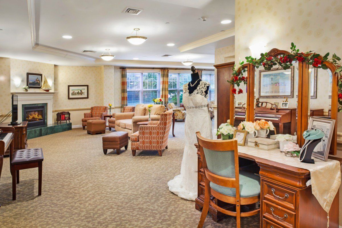 A stylish living room featuring classic furniture and a bridal gown on display.
