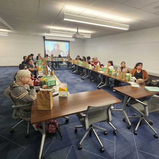 A group of participants engaged in a meeting in a conference room, with tables arranged for discussion.
