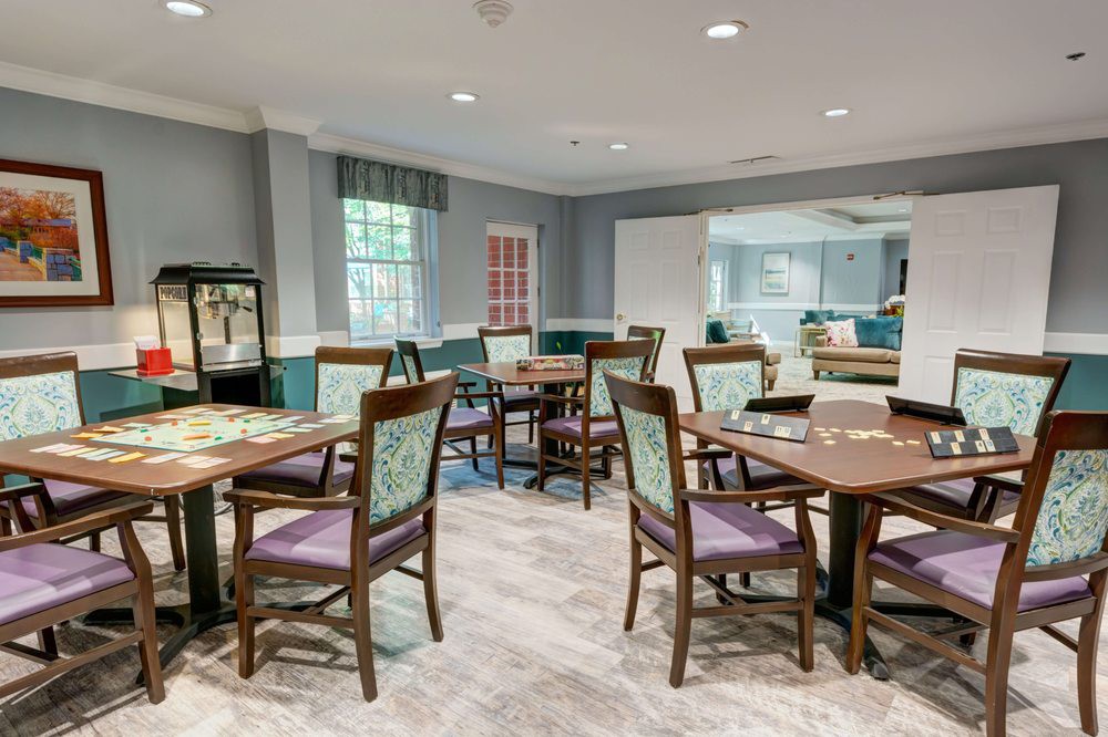A spacious and well-lit dining room with multiple tables and chairs arranged neatly.