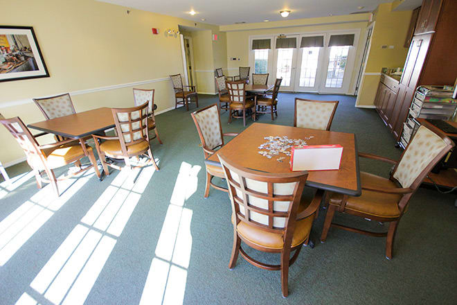 A well-lit dining area with neatly arranged tables and chairs, ideal for community gatherings.