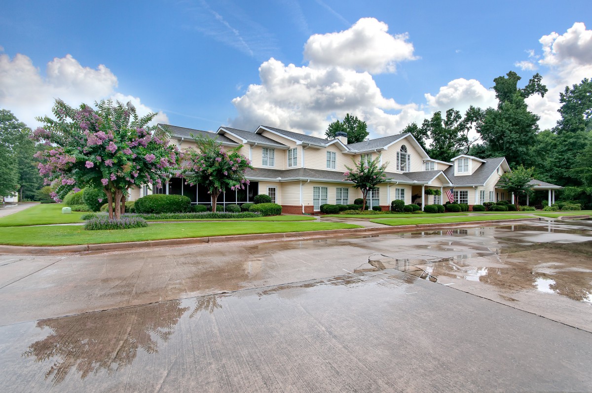 A picturesque residential house with a well-maintained front yard and a cloudy sky overhead.