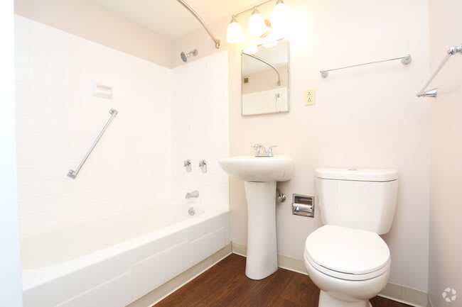 A clean and modern bathroom with a bathtub, sink, and toilet.