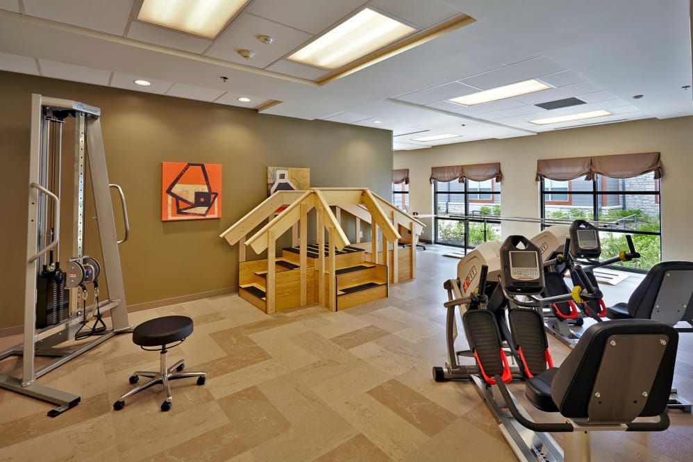 A fitness center with exercise equipment and rehabilitation structures.