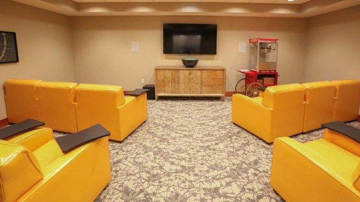 A cozy living room setup with bright yellow chairs and a popcorn machine.