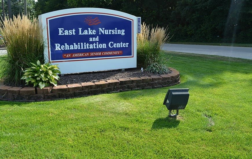 Sign for East Lake Nursing and Rehabilitation Center surrounded by landscaping.