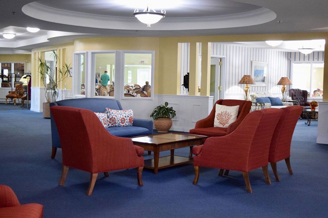 A cozy living room with colorful seating and a central coffee table.