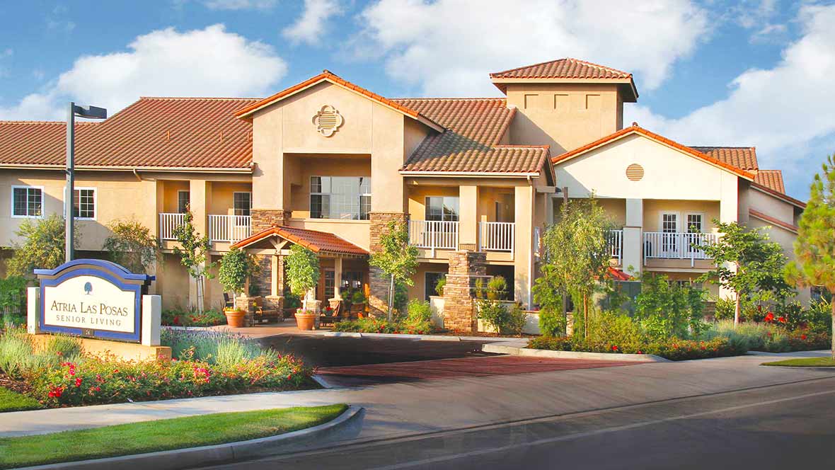 A modern residential building with stylish architecture and landscaped surroundings on a sunny day.