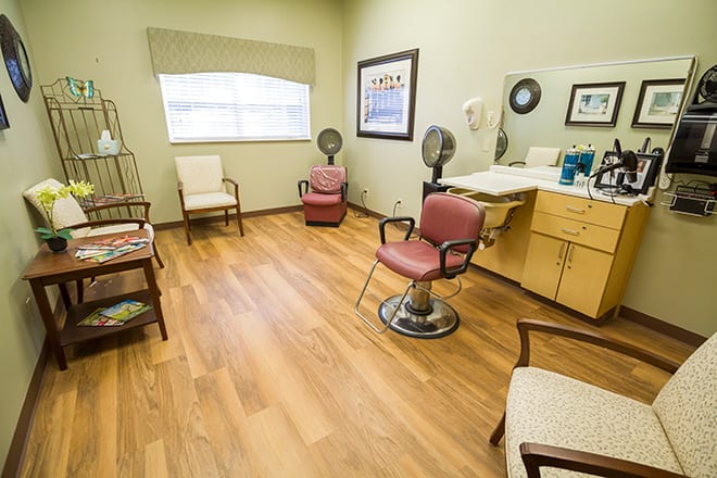 A cozy hair salon with barber chairs and a wooden floor.