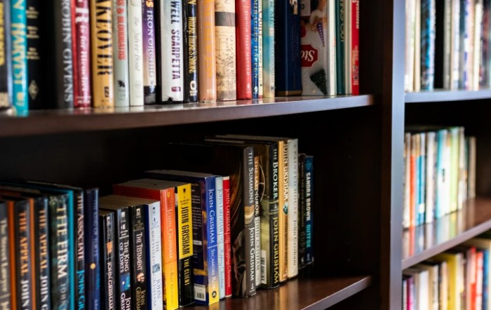 A wooden bookshelf filled with a variety of books.