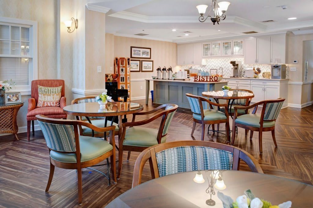 A cozy dining area with tables and chairs, featuring a warm interior design.