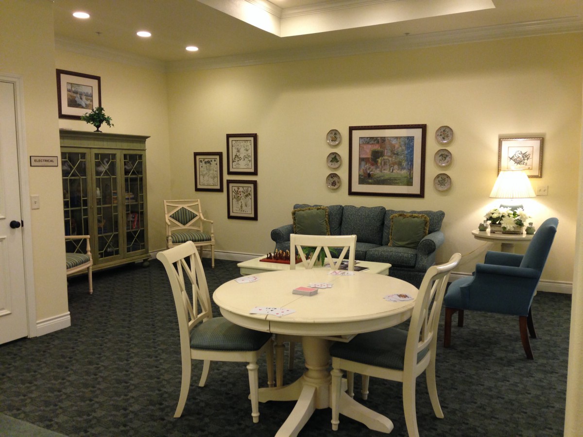 A cozy living room with a round dining table and chairs, featuring a sofa and decorative elements.