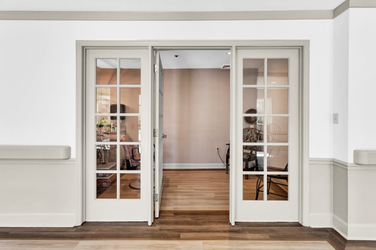 A modern office space with sliding glass doors and wooden flooring.