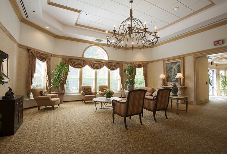 Elegant lobby with a large chandelier, comfortable seating, and large windows.