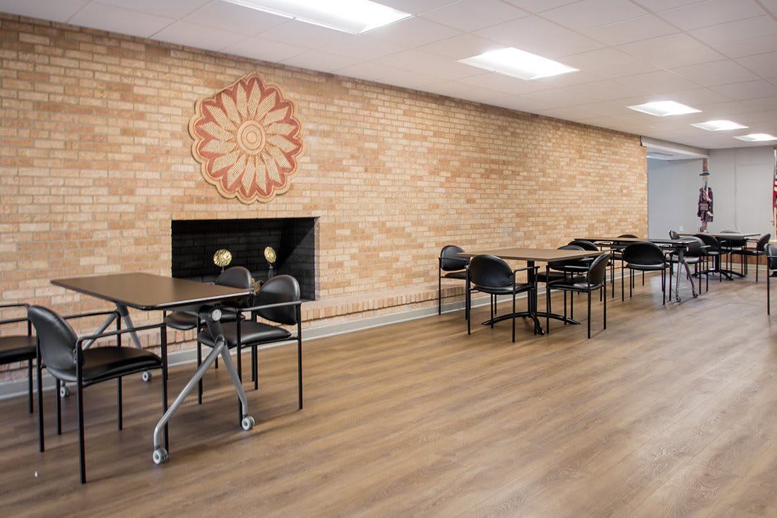 A modern dining area with brick walls, minimalist decor, and several tables and chairs.