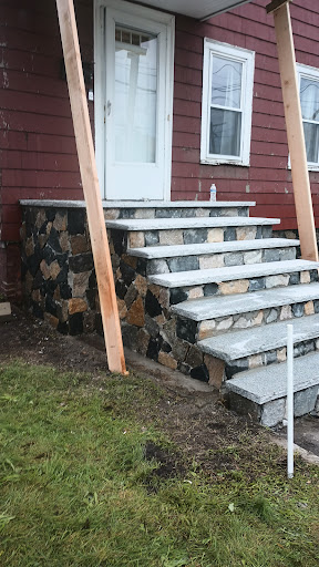 A newly constructed stone staircase leading up to a front door, featuring a rustic design.