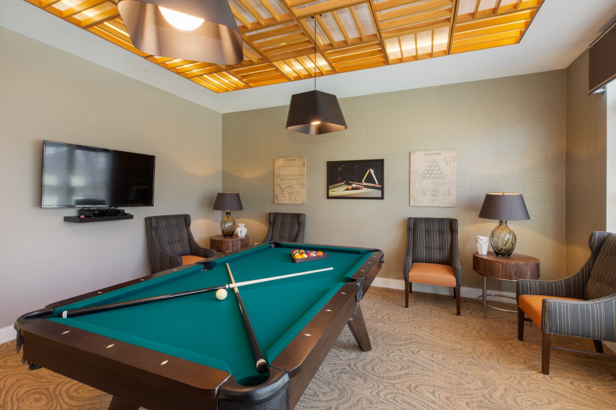 A stylish game room featuring a pool table and comfortable seating.