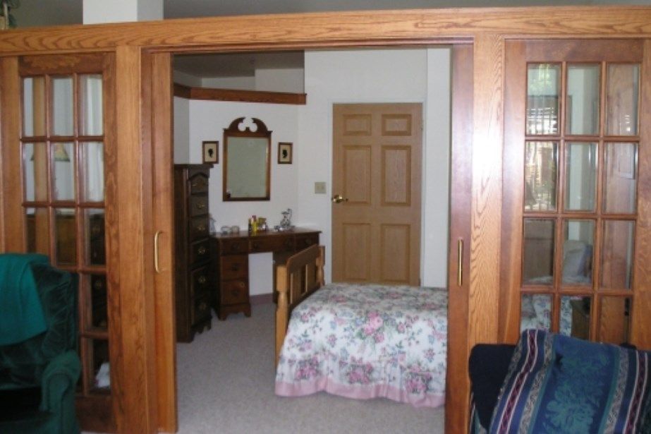 A cozy bedroom with wooden furniture and a floral bedspread.