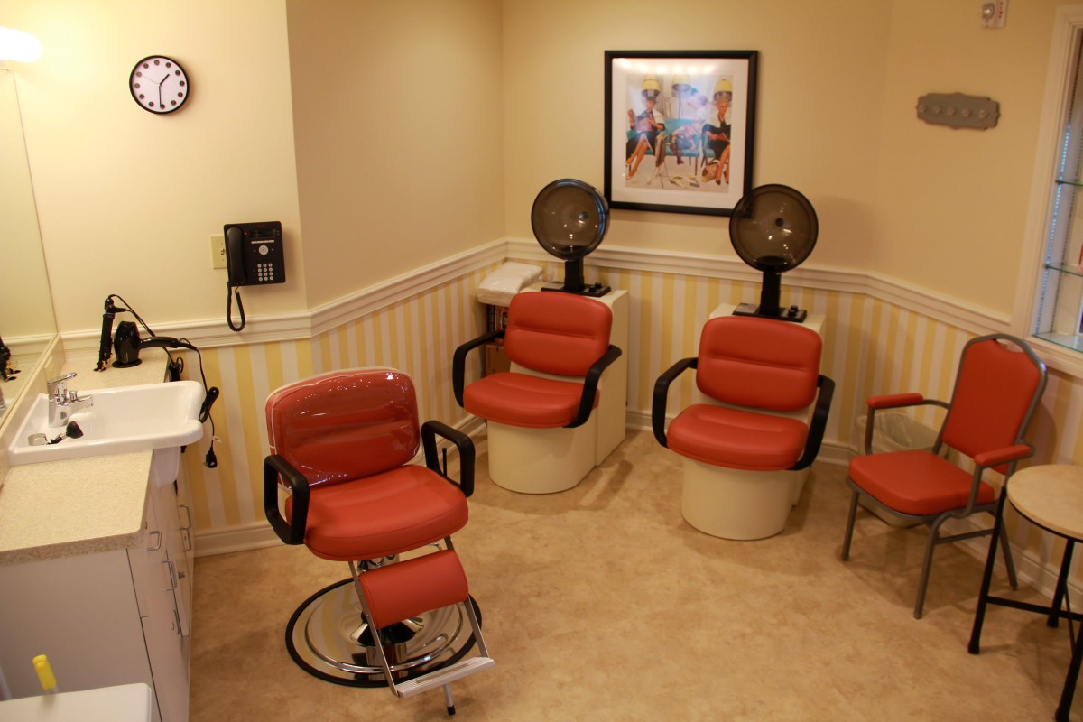 A retro-style salon interior with red chairs and hair dryers.