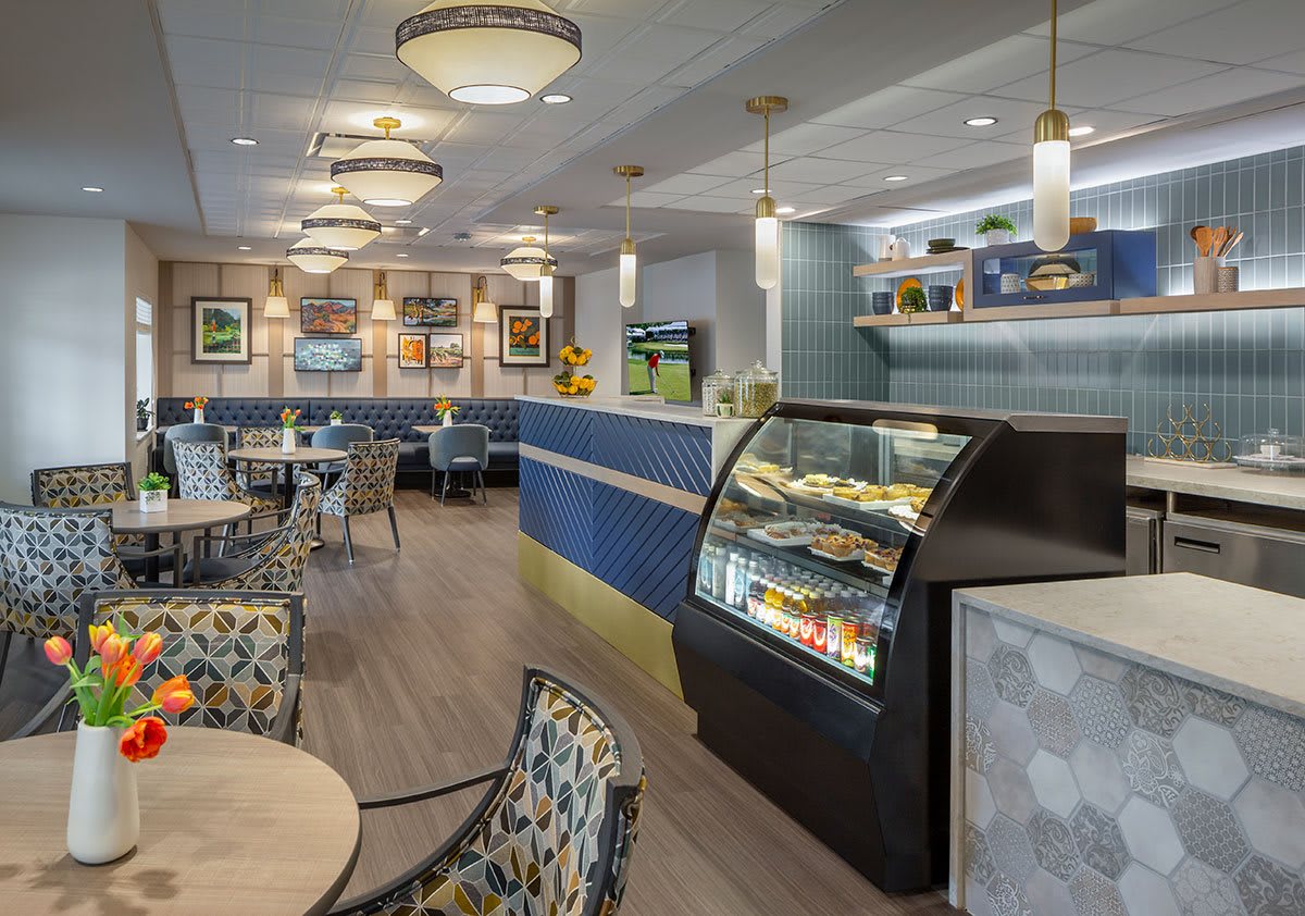 A modern cafe interior with a seating area and a display case for pastries.