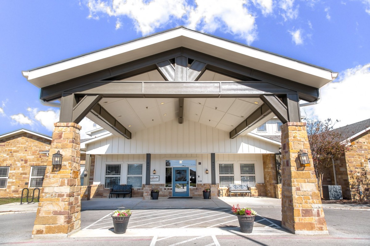 An inviting entrance of a modern building with a covered porch and stone accents.