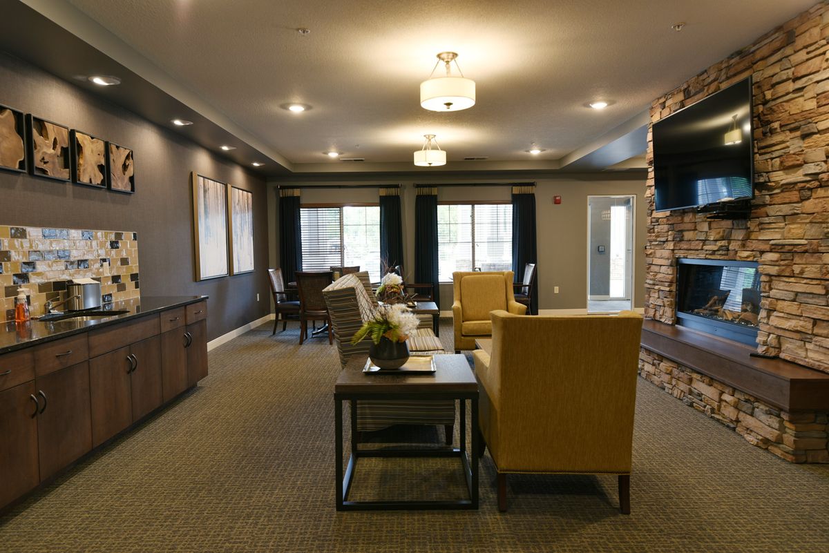A modern living room featuring stylish furniture and a brick accent wall.