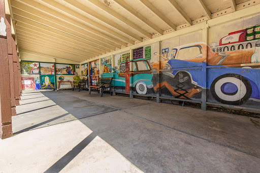 A vibrant mural depicting classic cars in a spacious interior setting.