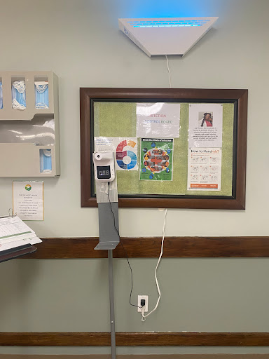 A view of a patient room in a hospital featuring medical equipment and a bulletin board.