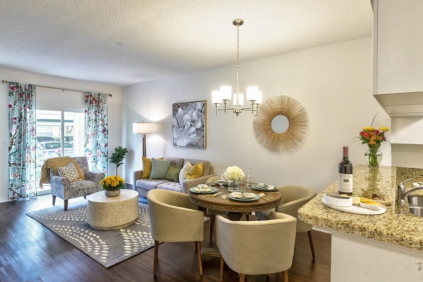 A cozy living room and dining area with modern decor, featuring a sofa, dining table, and stylish lighting.