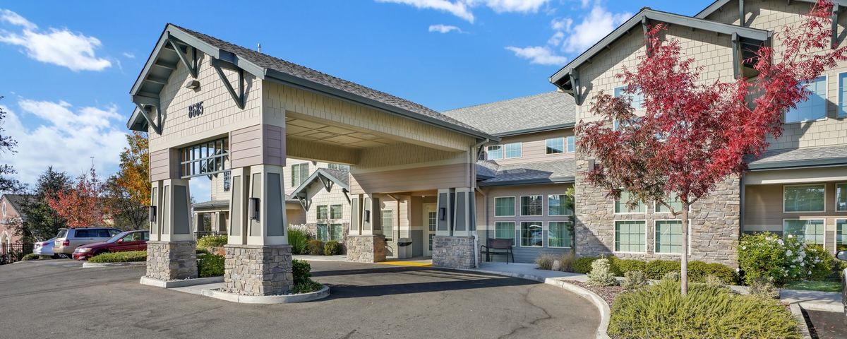 A modern residential building with a covered entrance and driveway.