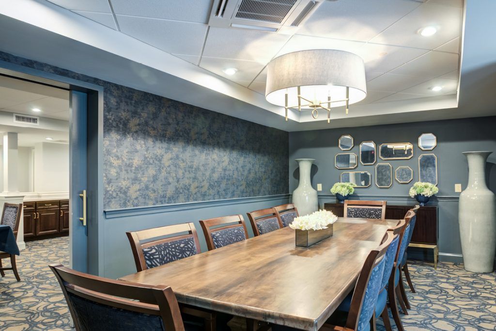 A stylish conference room with a large wooden table, elegant chairs, and decorative wall art.