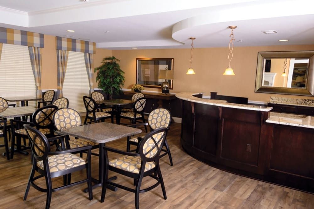 A modern dining area with tables, chairs, and a bar counter.