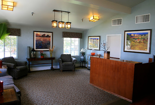 A cozy and welcoming lobby space featuring comfortable furniture, decorative artwork, and warm lighting.