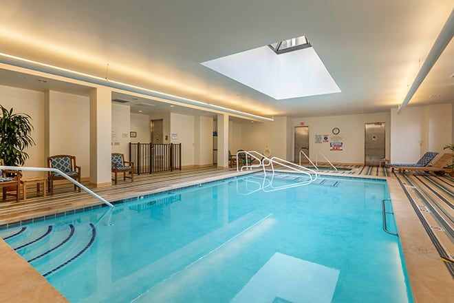 A modern indoor swimming pool with a skylight, offering a bright and inviting recreational space.