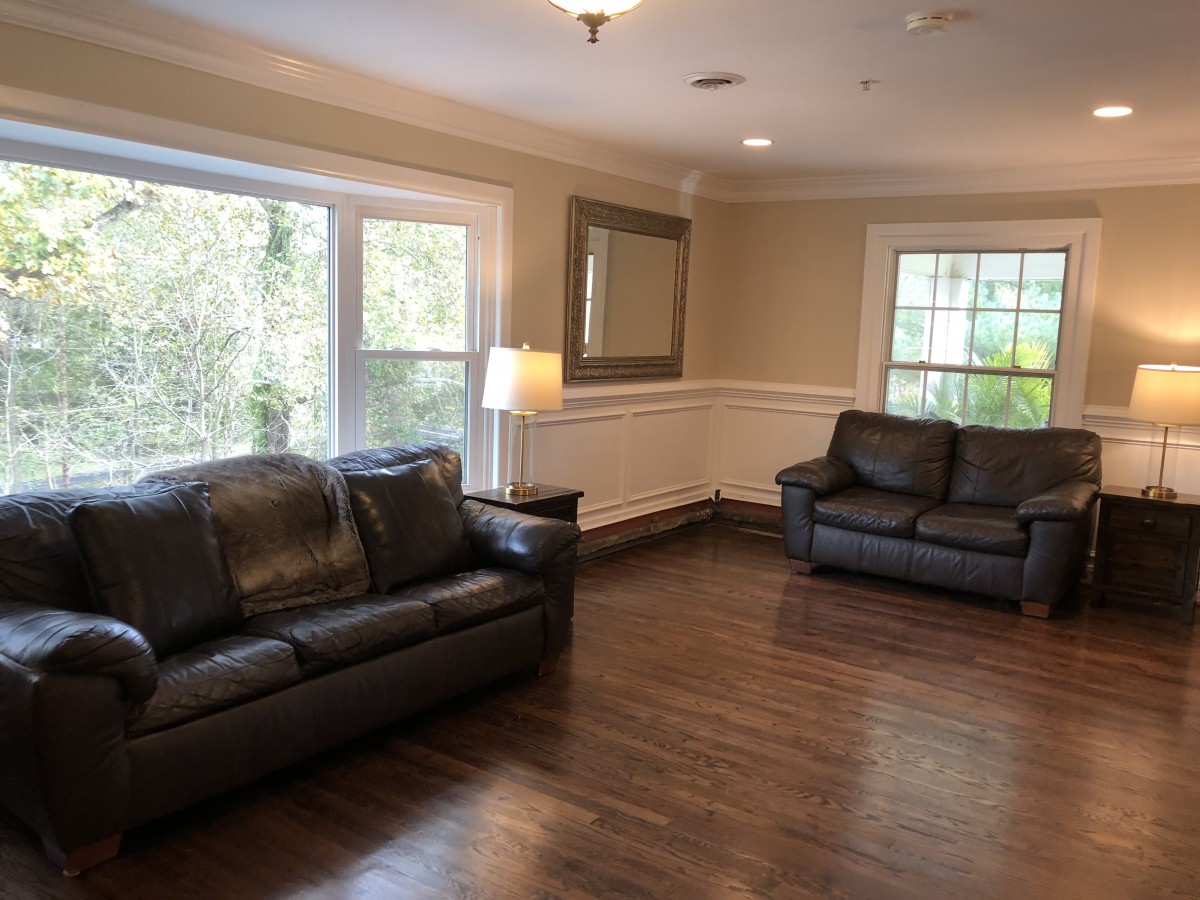 A cozy living room with leather sofas and large windows.