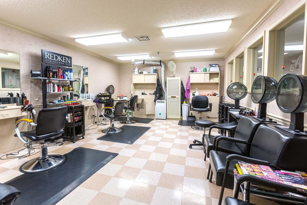 Interior view of a well-lit hair salon with styling chairs, mirrors, and hairdressing equipment.