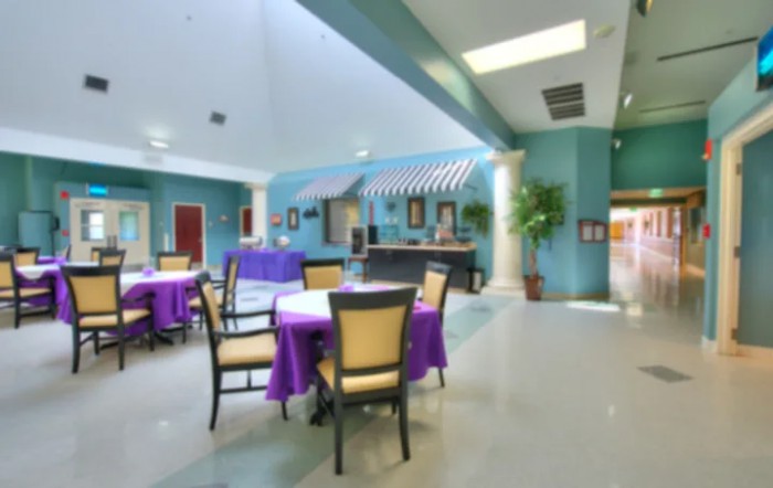 A bright and colorful dining area featuring blue walls, purple tablecloths, and comfortable seating.