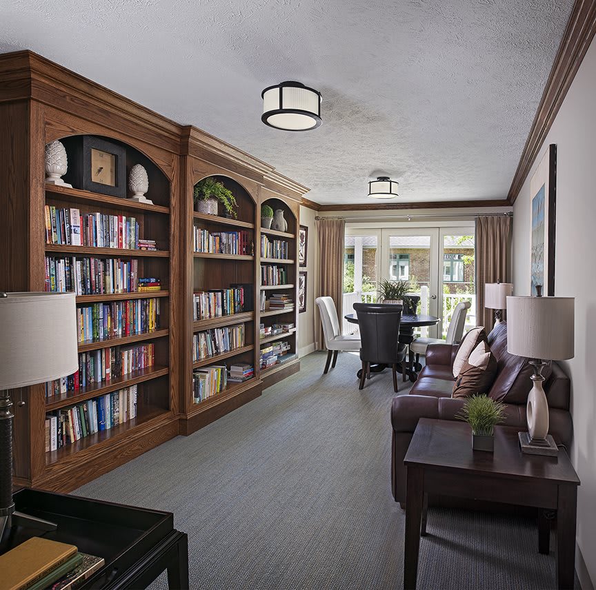 A cozy library with wooden bookshelves and a comfortable seating area.