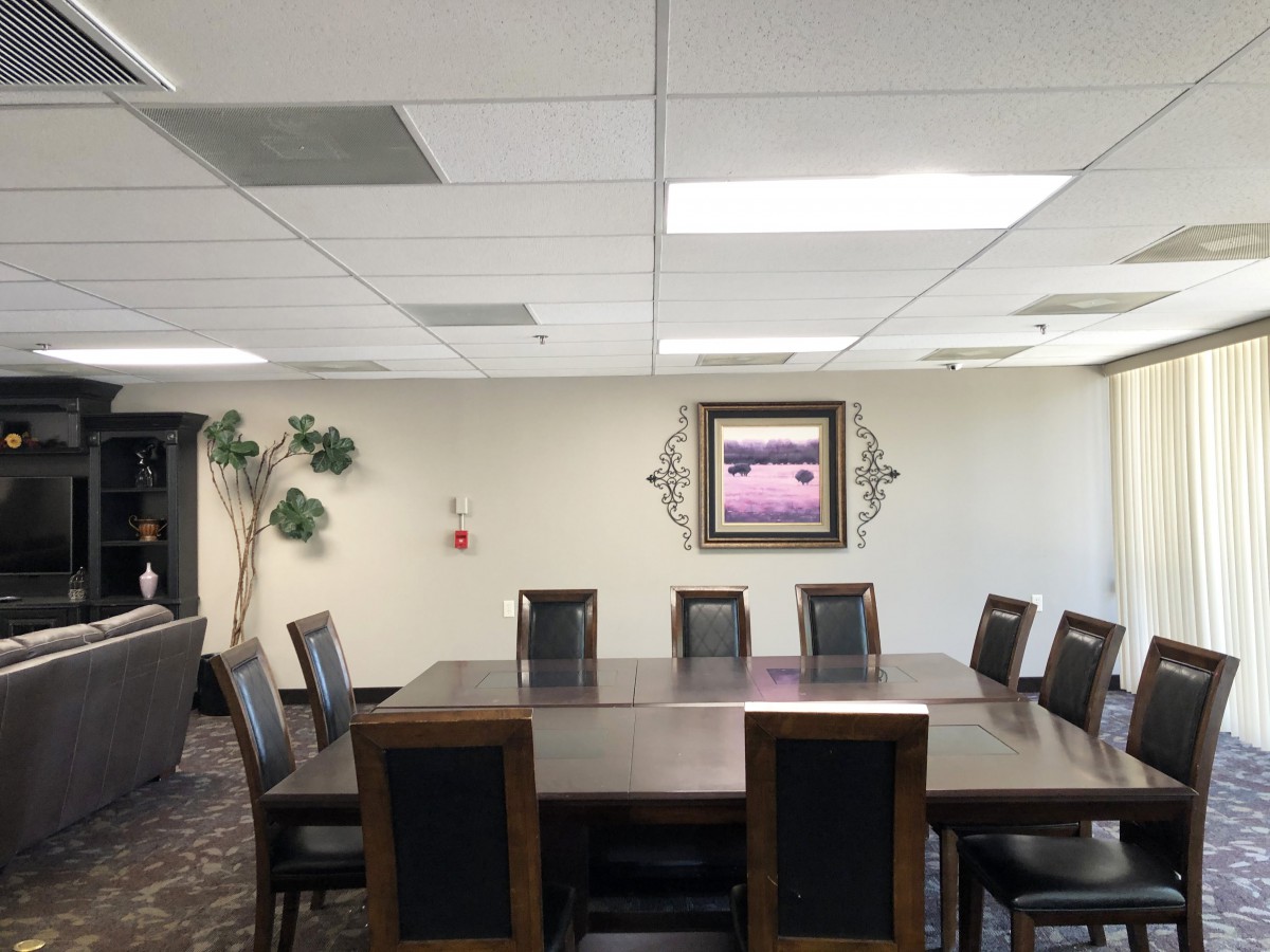 A well-lit conference room with a large meeting table, chairs, and decorative elements on the walls.