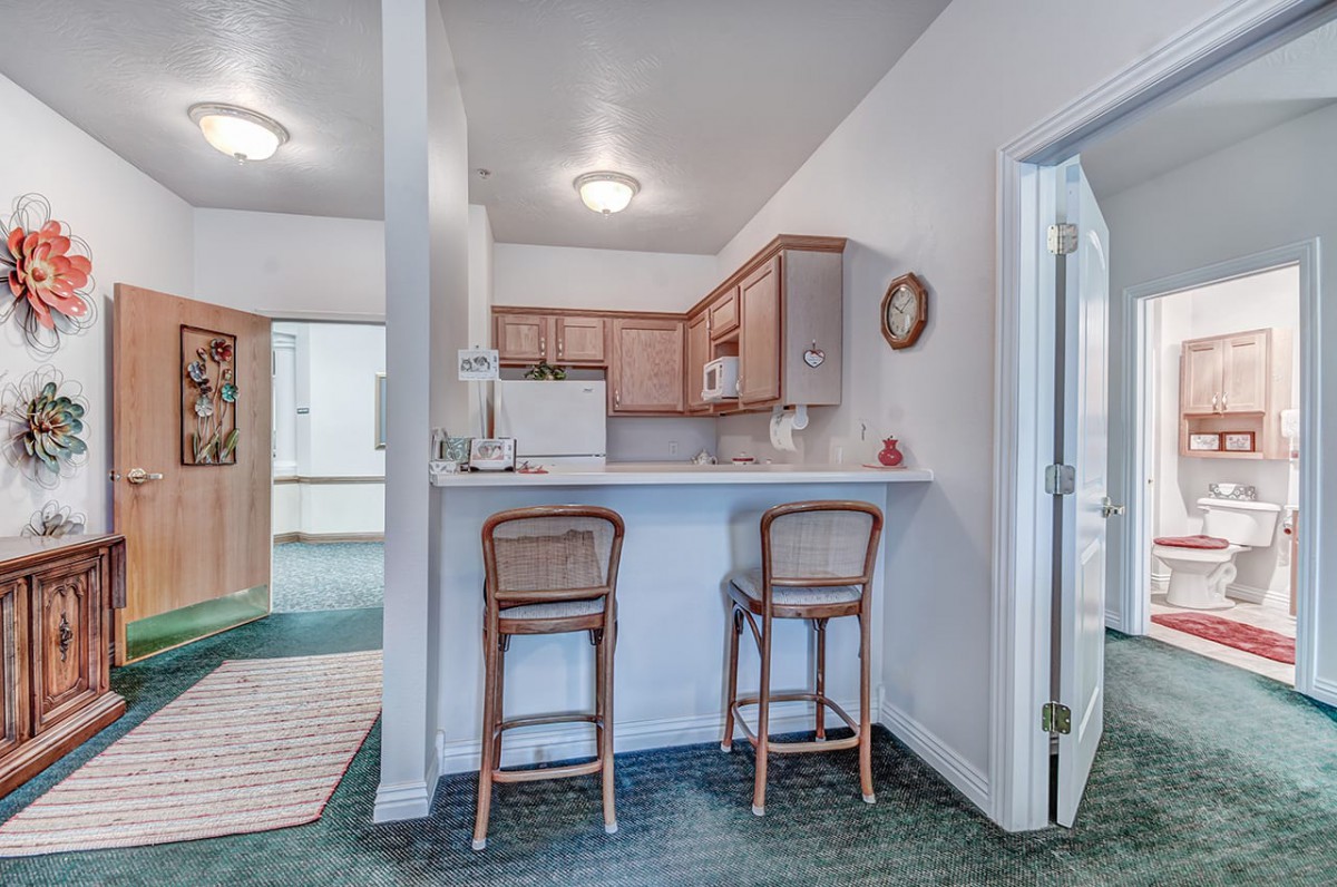 A compact kitchen with bar seating in an open-plan apartment.