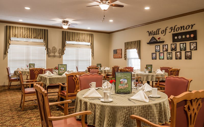 A well-arranged dining room with elegantly set tables and warm decor.