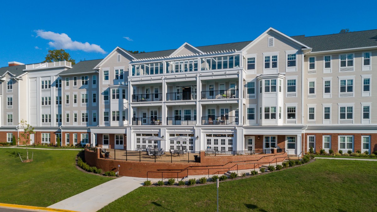 A modern residential apartment building with multiple balconies on a sunny day.