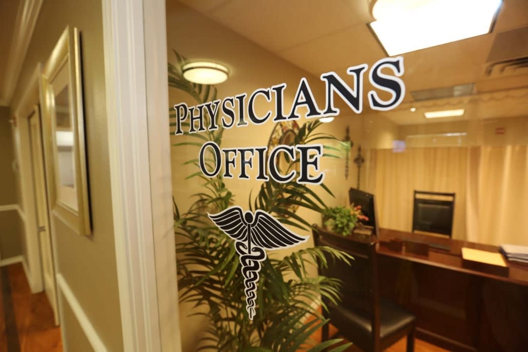 Entrance to a physician's office featuring glass doors with medical emblem.
