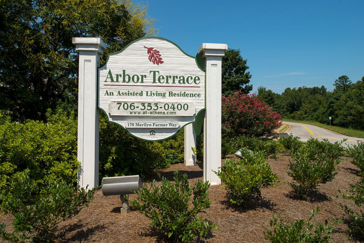 A sign for Arbor Terrace, an assisted living residence, surrounded by landscaping.