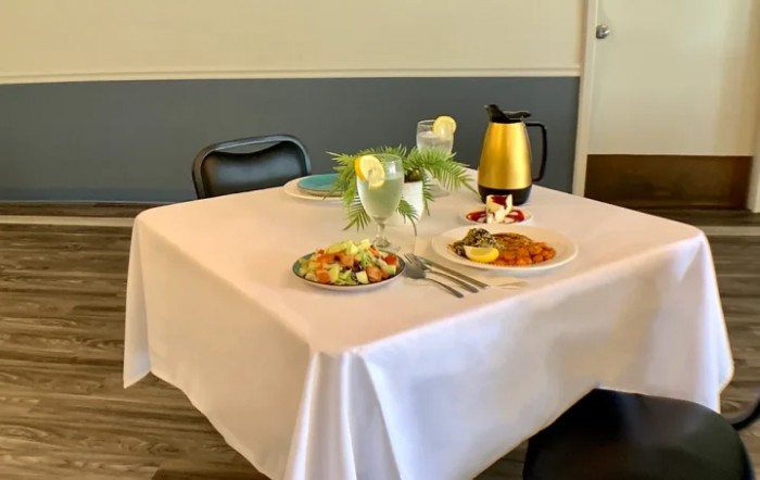 A neatly set dining table with plates of food and drinks in a restaurant setting.
